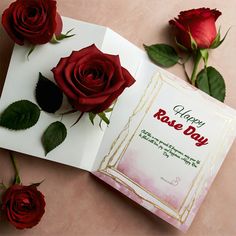 two red roses sitting on top of an open book with the words happy rose day