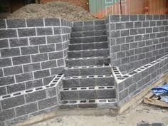 cinder blocks are stacked on top of each other in order to form a retaining wall