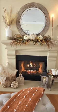 a living room with a fire place and mirror on the wall above it's mantle