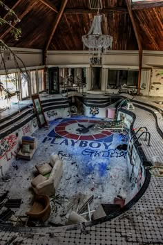 an abandoned swimming pool with graffiti all over the floor and walls, in front of a chandelier