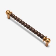 a gold and brown beaded handle on a white background