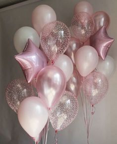 a bunch of pink and white balloons with stars on them