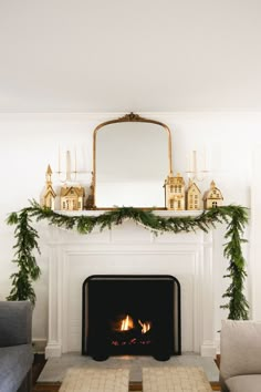 a living room filled with furniture and a fire place in front of a mantle covered in greenery