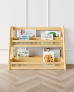 a wooden shelf with books on it in front of a white wall and wood floor