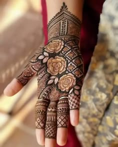 a woman's hand with hennap and flowers painted on the palm,