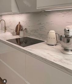 a kitchen with marble counter tops and white cabinets