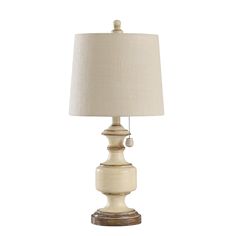 a white table lamp with a beige shade