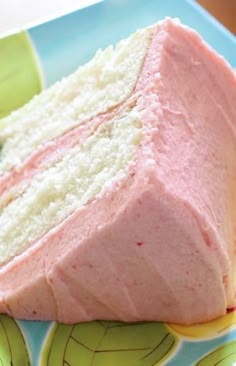 a piece of cake sitting on top of a blue and green plate with pink frosting