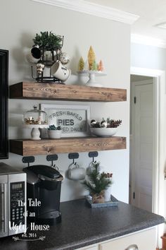 three wooden shelves with plants and other decorations on top of them in a white kitchen