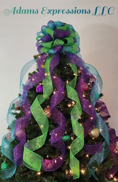 a decorated christmas tree with purple and green ribbons