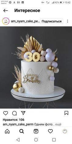 a white cake with gold decorations on top and the words happy birthday written in russian