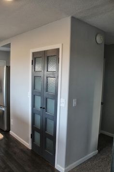 an empty kitchen with stainless steel appliances and wood flooring, is pictured in this image