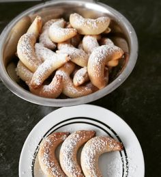 powdered sugar covered donuts in a bowl and plate