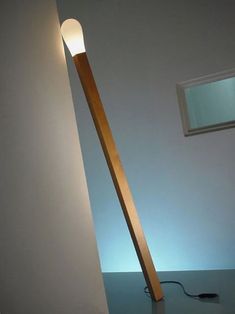 a lamp that is sitting on top of a table next to a window and wall