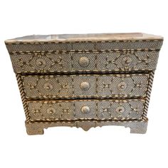 an ornately decorated chest of drawers with marble top and brass accents on the sides