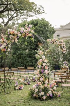 an outdoor ceremony setup with flowers and chairs