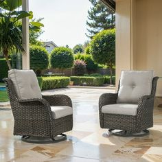 two wicker chairs sitting on top of a tile floor in front of a house