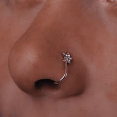 a nose piercing with a flower on the tip of it's nose is shown