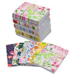 a stack of paper with flowers on it and one folded in pink, green, yellow and blue