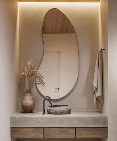 a bathroom sink with a mirror above it and a vase on the counter next to it