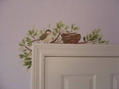 two birds sitting on top of a tree branch next to a door with a nest in it