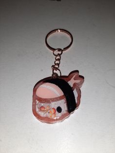 a close up of a keychain with a cartoon character wearing a hat on it