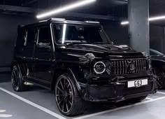 a black mercedes g class parked in a parking garage