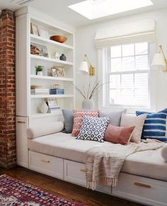 a living room filled with lots of furniture and bookshelves next to a window