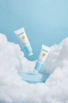 two tubes of sunscreen sitting in the clouds