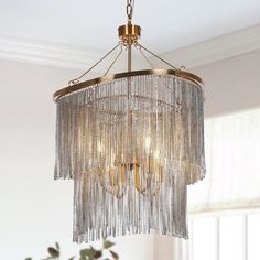 a chandelier hanging from the ceiling in a room with white walls and windows