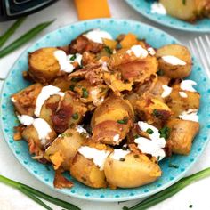 a blue plate topped with potatoes covered in sour cream