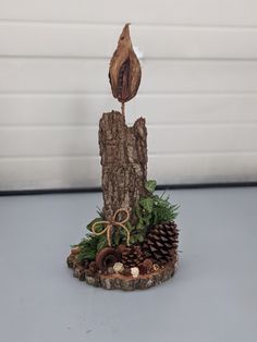 a piece of wood that has been made into a tree stump with pine cones on it