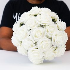 a man holding a bouquet of white roses