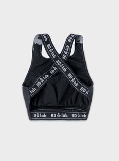 The BDlab Sportswear Cross Back Sports Bra is a medium-to-high impact workout top with a flattering higher neckline and bold branded elastic wide cross strap back. While engineered for killer workouts, it doubles equally as a high-fashion crop for every day. Constructed with Recycled Polyester fabric meticulously sewn in NYC. Style it with our Performance Legging for workouts for a sporty / casual look or pair with our Cargo Pant, Flared Trouser or Adventure Short for an It Girl street look. Fou Black Cross Back Activewear With Built-in Padding, Black Cross Back Athleisure Top, Sporty Black Top With Cross Back, Black Breathable Cross Back Sports Bra, Black Breathable Cross-back Sports Bra, Black Moisture-wicking Cross-back Activewear, Black Cross Back Sports Bra For Gym, Breathable Black Activewear With Cross Back, Black Breathable Activewear With Cross Back