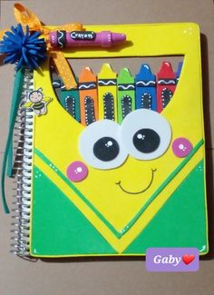 a yellow notebook with crayons on it