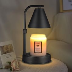 a lit candle sitting on top of a table next to a card and a flower