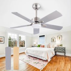 a bedroom with a bed, ceiling fan and hardwood flooring in the middle of it