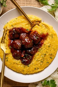 a white plate topped with mashed potatoes covered in ketchup and garnished with parsley