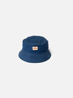 Bucket hat made from organic and recycled cotton. At 80% virgin organic cotton, the tightly woven lightweight denim offers great durability.  Kids grow, but clothes don't. When the hat is outgrown, hand it down. Or trade it in at any Nudie Jeans Repair Shop!     Interested to know more about our Utility Denim? Happy to hear it:  Nudie Jeans Utility Denim is our take on the denim of the best chore coats, dungarees, and carpenters' pants from the 1930s, which utilizes fine, high-twist yarns togeth Jeans Repair, Recycle Jeans, Chore Coat, Repair Shop, Nudie Jeans, Hat Making, Dungarees, Recycled Cotton, Bucket Hat