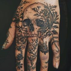 a hand with a skull and flowers on it