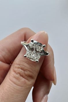 a woman's hand holding an engagement ring with two diamonds on it and the middle one in white gold