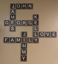 a cross made out of scrabble tiles that says john and george is family