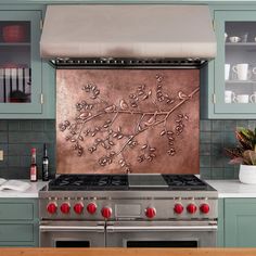 a stove top oven sitting inside of a kitchen next to a wall covered in flowers