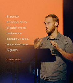 a man standing in front of a projection screen giving a speech to someone on the stage