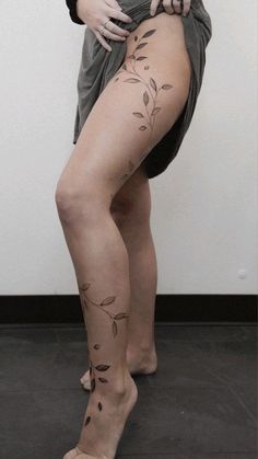 a woman with tattoos on her legs is posing