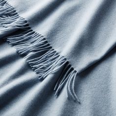 a blue blanket with fringes laying on top of it