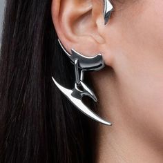 The Cyberpunk Metal Dagger Ear Cuffs are a bold and edgy accessory for anyone looking to make a statement. Crafted from high-quality metal, these ear cuffs feature a unique dagger design that curves along the contour of the ear, offering a striking visual contrast against the skin. They are designed to be comfortable for prolonged wear, fitting securely around the ear without the need for piercing. Perfect for adding a touch of rebellious style to any outfit, these ear cuffs are ideal for those Punk Metal Ear Cuff For Party, Techwear Earrings, Silver Punk Style Metal Ear Cuff, Futuristic Earrings Ear Cuffs, Dragon Cuff Earrings, Dagger Design, Dark Tiger, Unique Clothing Stores, Gothic Grunge