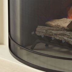 a fire burning in a fireplace with logs on the side and wood sticking out of it