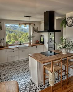 a kitchen with a table and chairs in it next to a clock on the wall