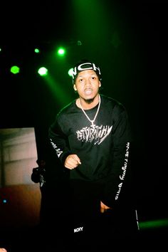 a man standing on top of a stage in front of green lights